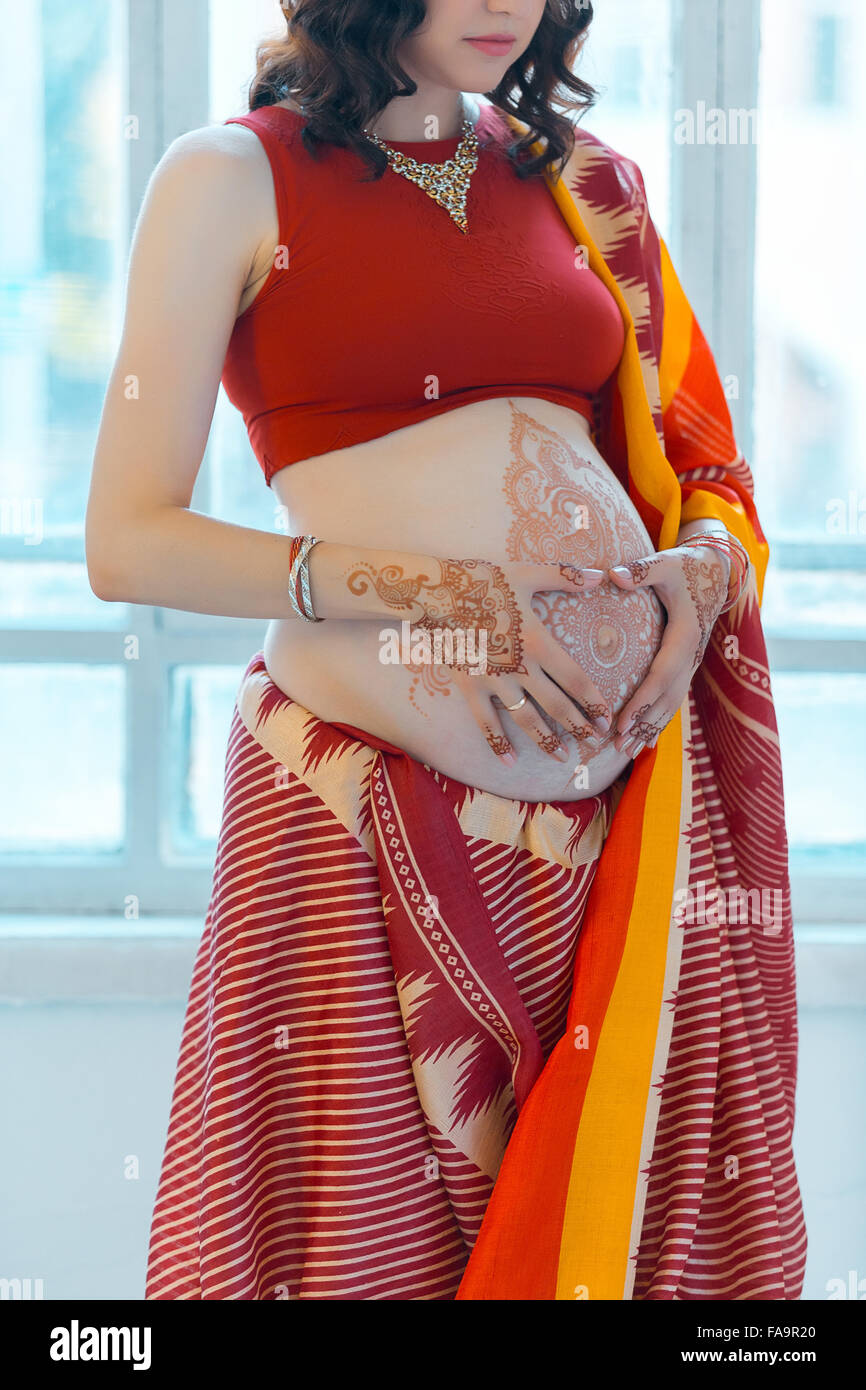 The pregnant woman belly with henna tattoo Stock Photo - Alamy