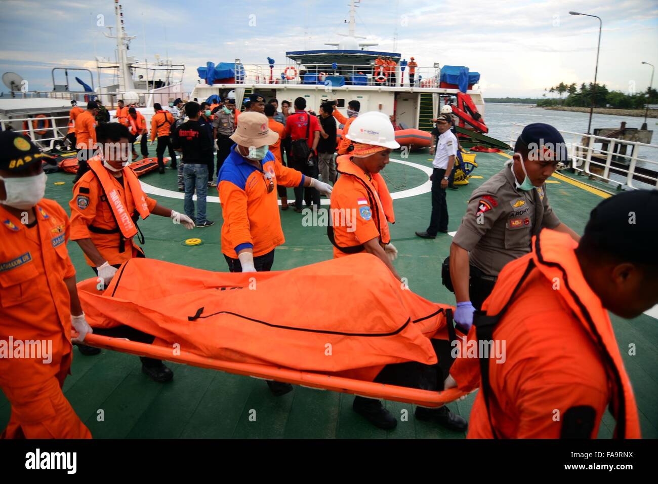 Sulawesi, Indonesia. 24th Dec, 2015. Members of Search and Rescue (SAR) team transfer bodies of the victims in South Sulawesi, Indonesia, Dec. 24, 2015. Rescuers have recovered 63 bodies and kept searching for 15 missing people whose chance of survival was slim five days after a boat sank in eastern Indonesia, officials said on Thursday. Credit:  Lukas/Xinhua/Alamy Live News Stock Photo