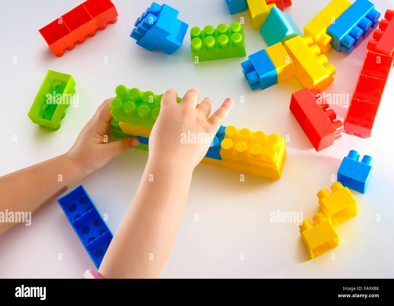 Baby girl playing with colorful blocks on white background Stock Photo ...