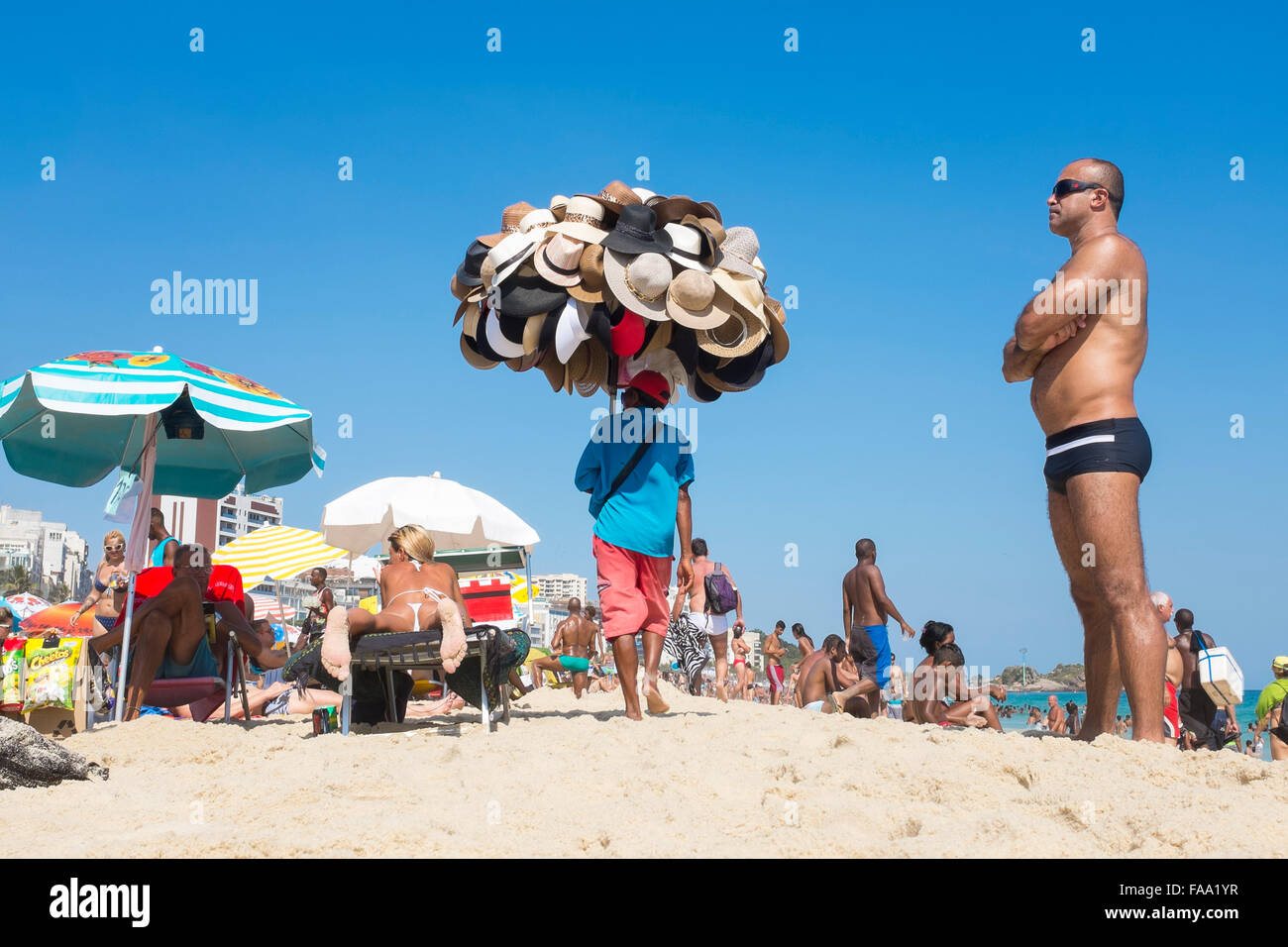 Rio De Janeiro Brazil March 05 13 Brazilian Beach Vendor Selling Hats Walks With Merchandise Among Sunbathers In Ipanema Stock Photo Alamy