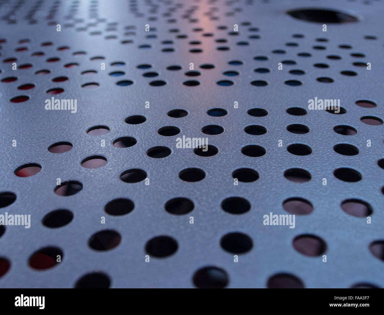 Metal table top with firelight glow at top and large hole right Stock Photo