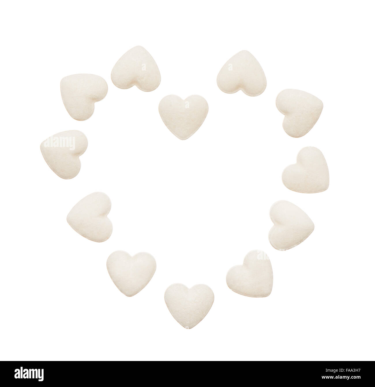Heart made of white heart shape tablets isolated on white background. Clipping path included. Stock Photo