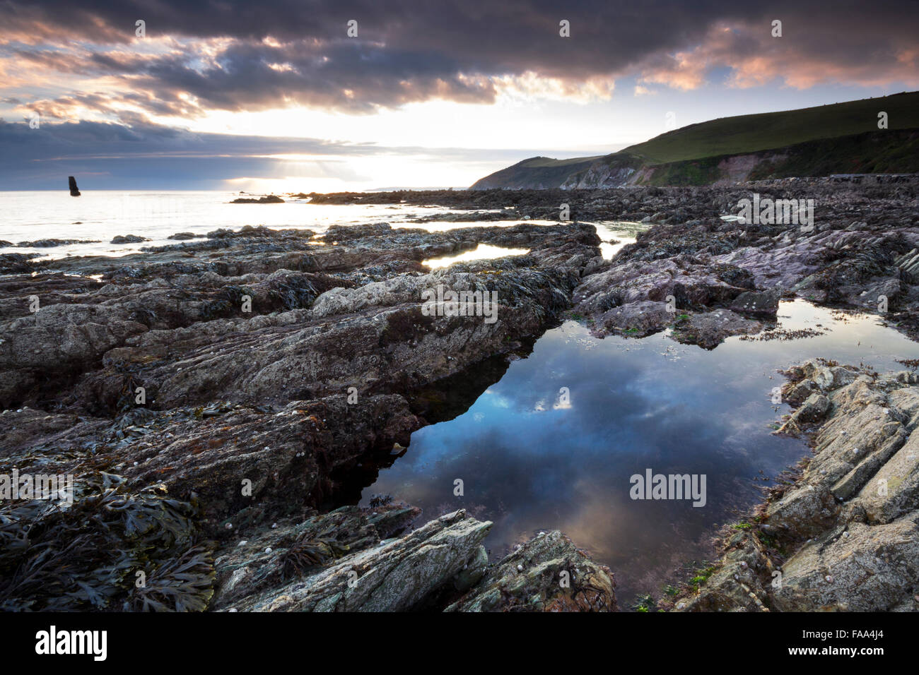 Sunset over the rocky beach at Portwrinkle Crafthole Cornwall UK Stock Photo