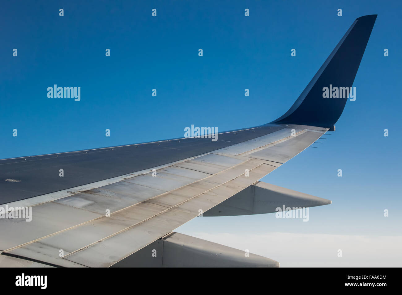 The wing of an airplane against a blue sky Stock Photo - Alamy