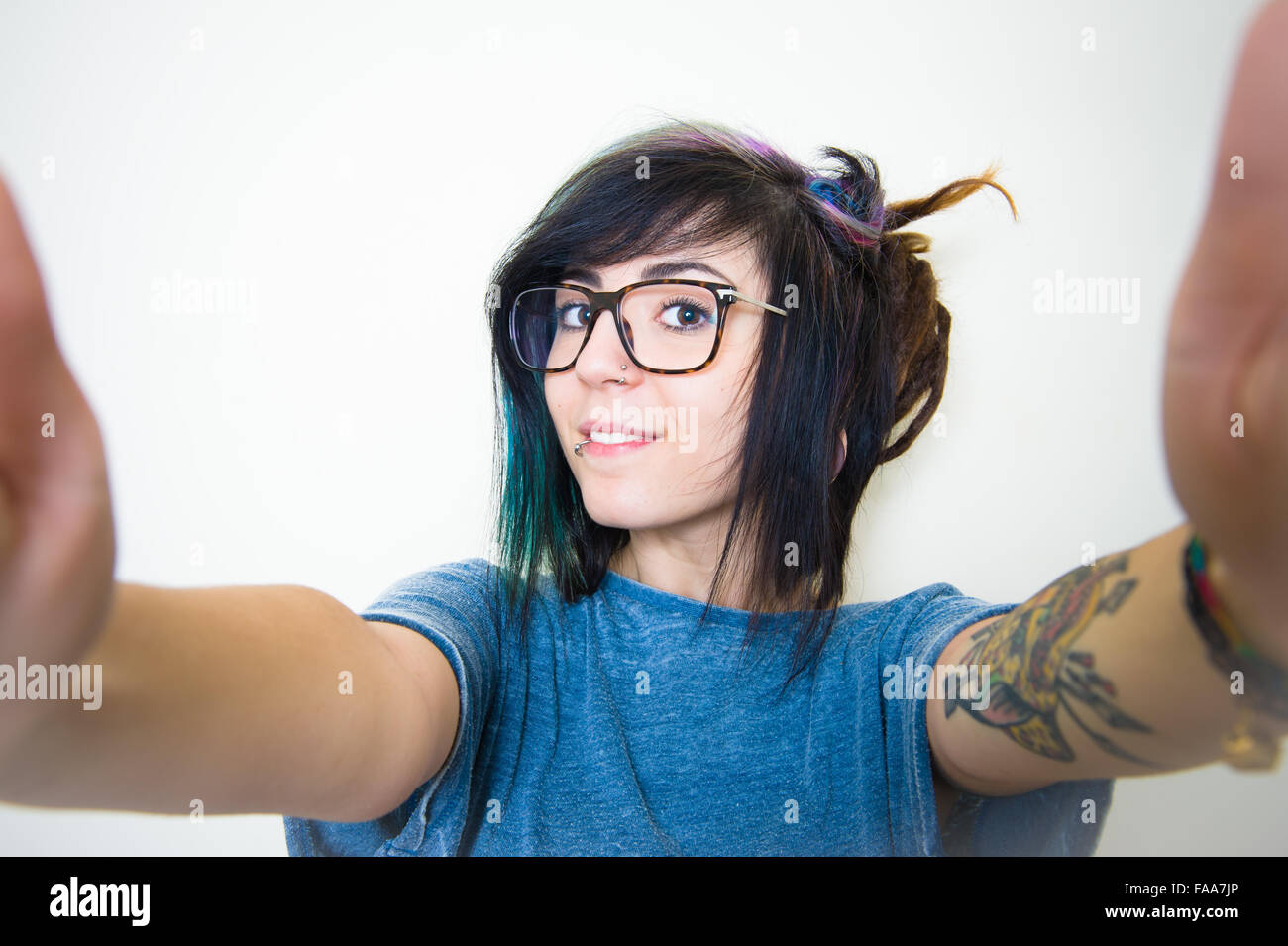 Pretty young teen woman smiling doing a selfie on white Stock Photo