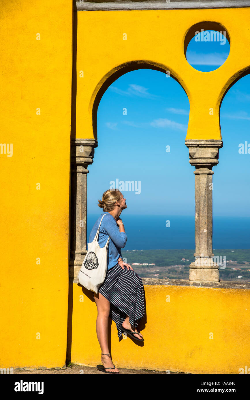 Girl Sitting At Yellow Wall At Sintra Castle In Portugal Stock Photo girl-sitting-at-yellow-wall-at-sintra-castle-in-portugal-stock-photo