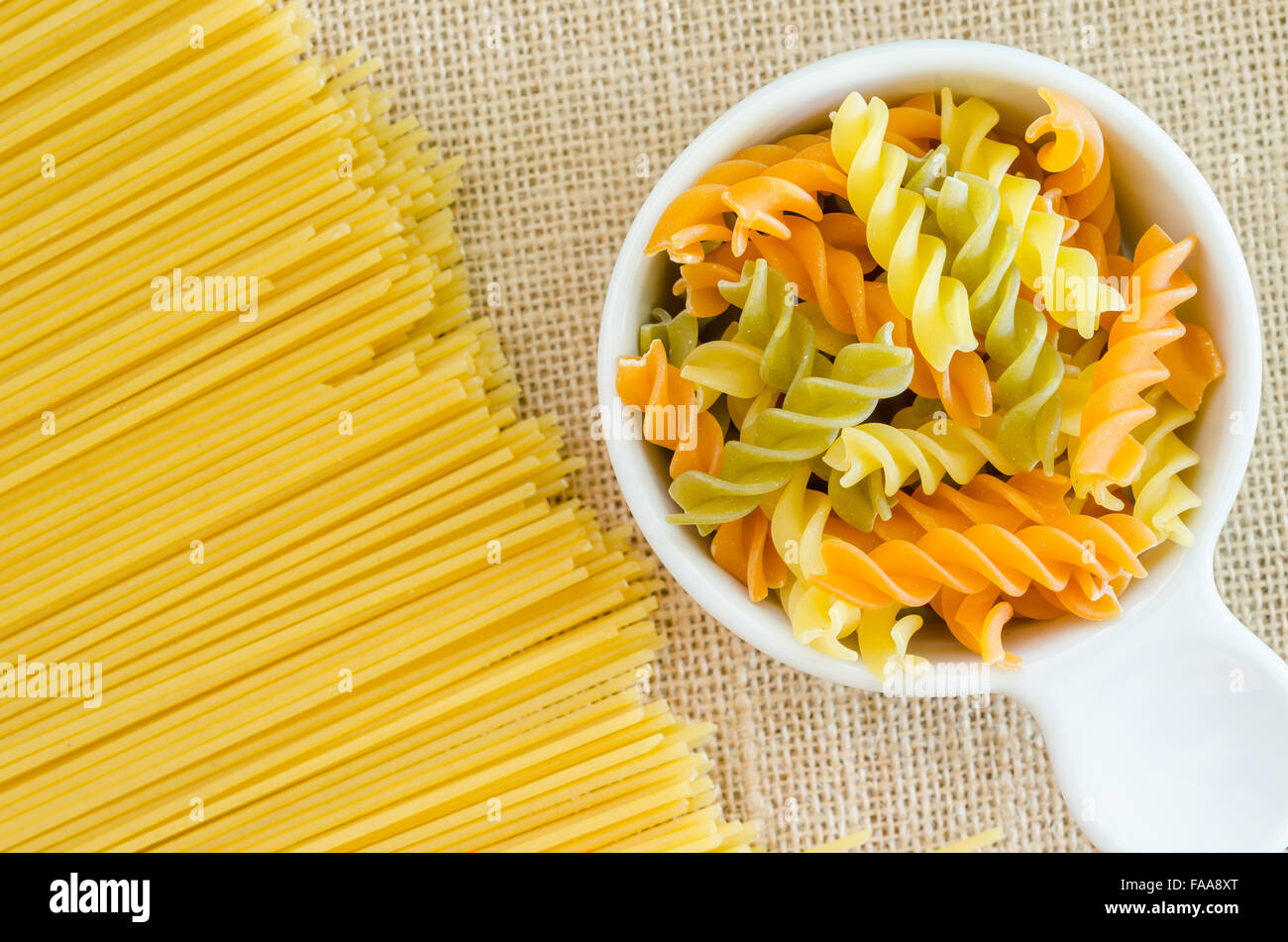 Italian raw pasta with uncooked pasta spaghetti macaroni on sack
