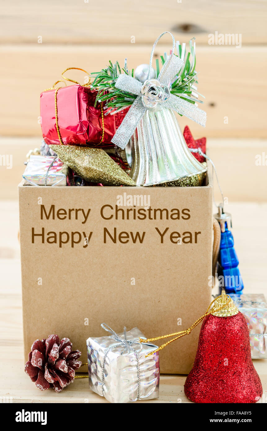 Christmas decoration in box with Merry Christmas and Happy New Year text on wooden background. Stock Photo