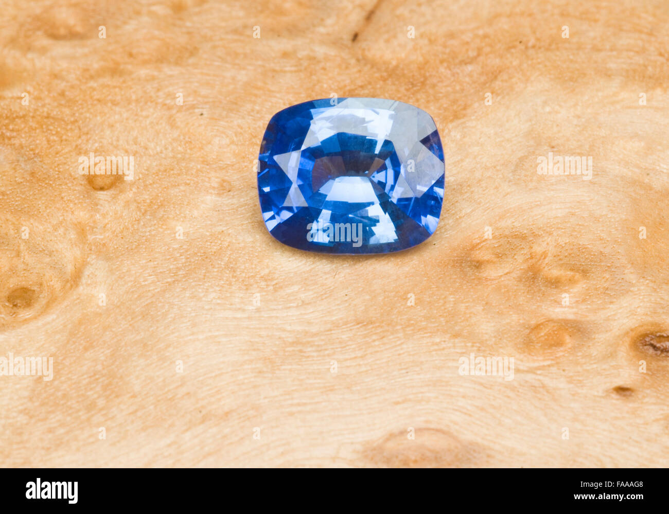 Large Blue Sapphire from Sri Lanka on natural timber background Stock Photo