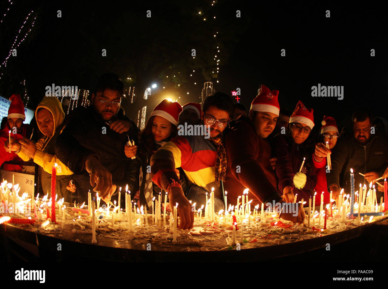 New Delhi, India. 25th Dec, 2015. People light candles as they offer