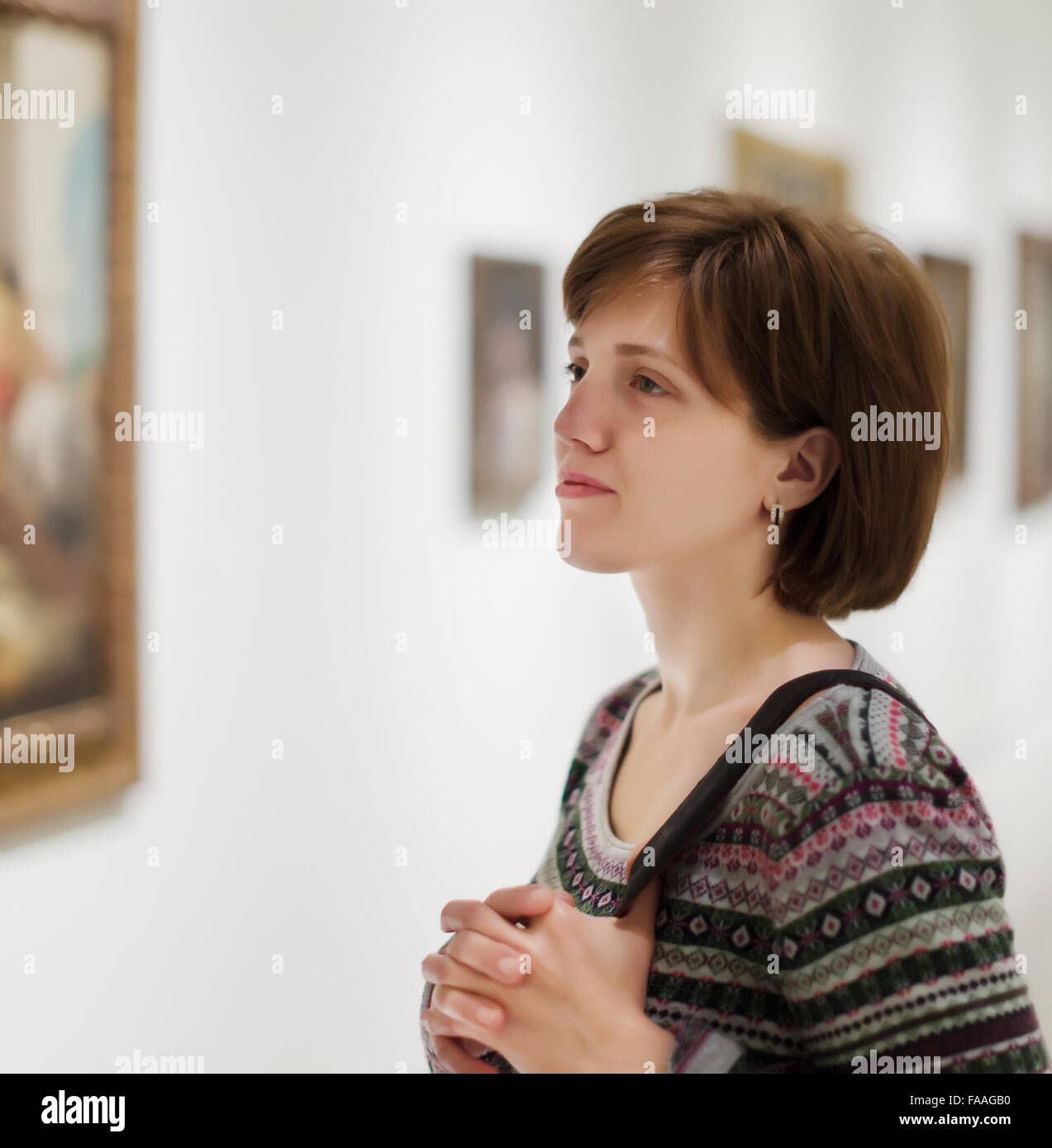 Young woman looking pictures in art museum Stock Photo - Alamy
