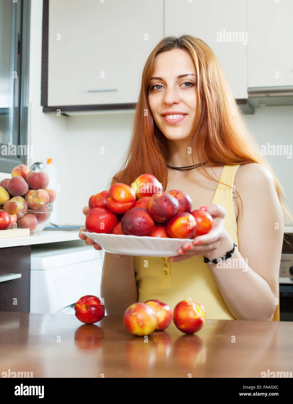 Young houswife holding nectarines at domestic kitchen Stock Photo Alamy