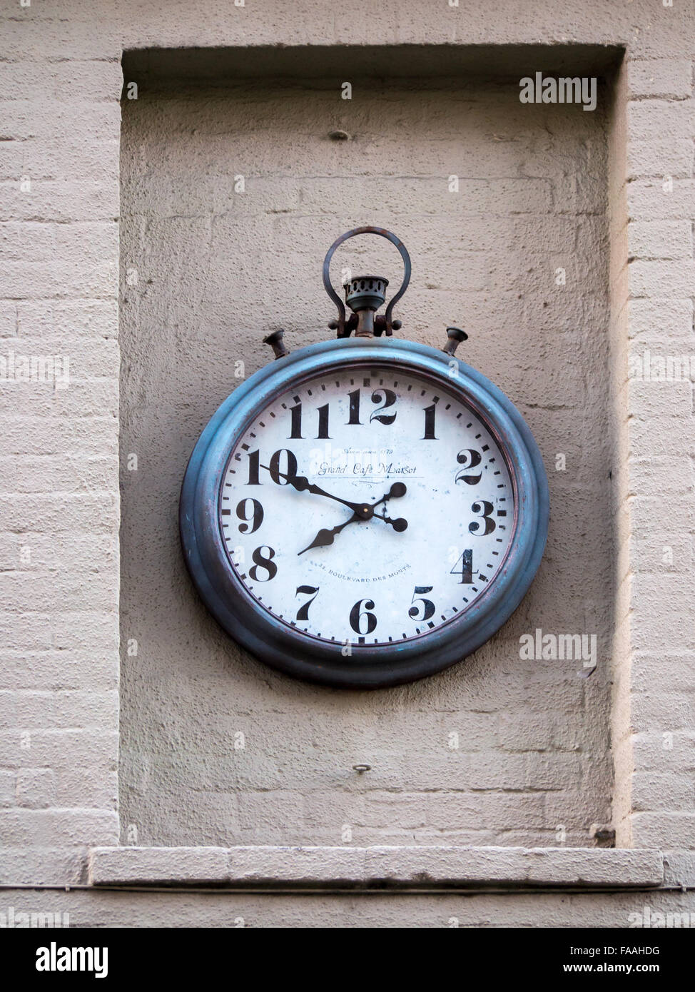 Clock in the form of a giant pocket watch on wall in Arundel Stock