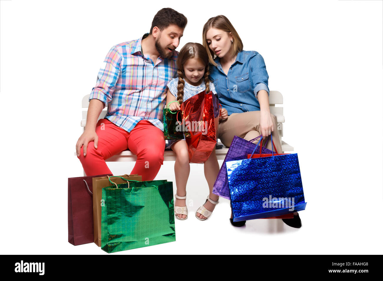 Happy family with shopping bags sitting at studio Stock Photo