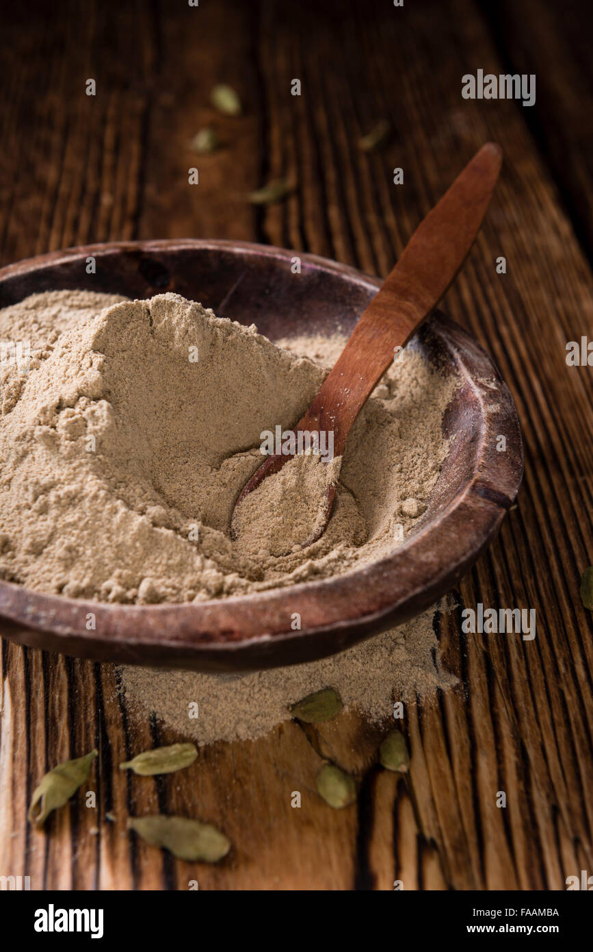 Portion of Cardamon Powder (close-up shot) on wooden background Stock Photo