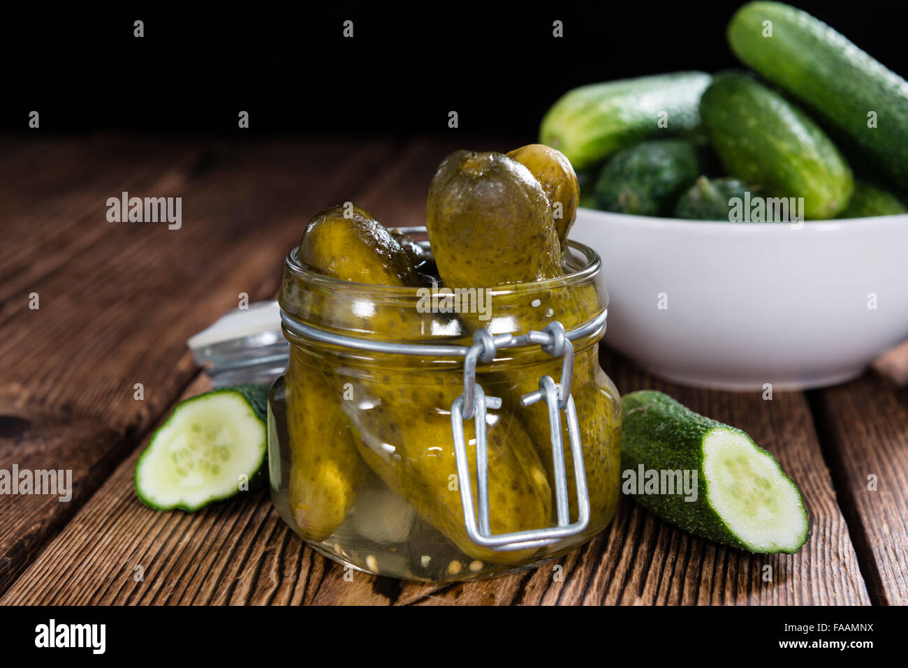 Preserved Gherkins (on wooden background) as detailed close-up shot ...