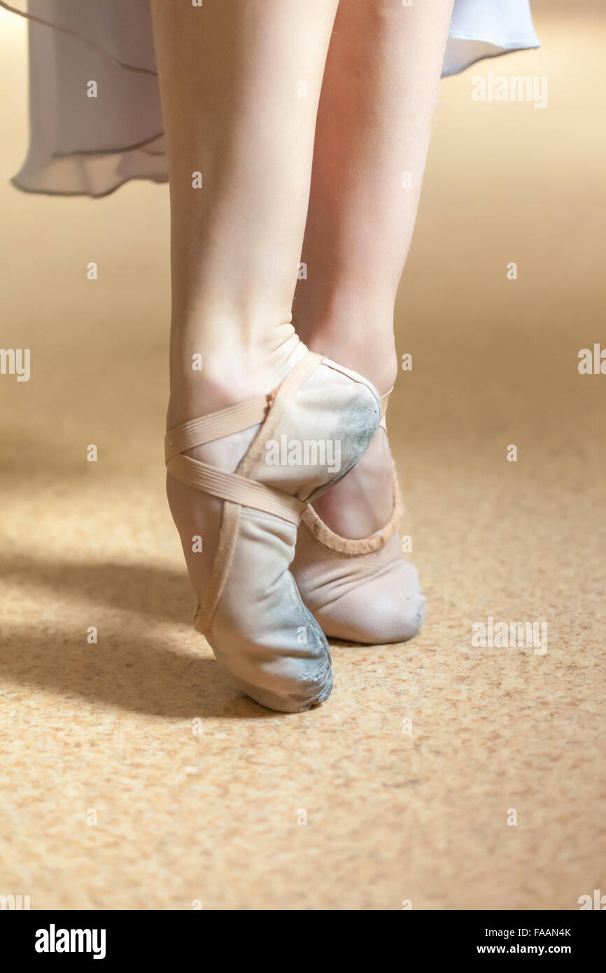 The close-up feet of young ballerina in  old pointe shoes Stock Photo