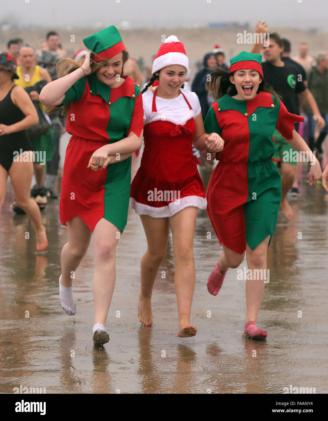 Porthcawl, UK. Friday 25 December 2015 Christmas swimmers in Santa and elf fancy dress run towards the seaRe: Hundreds of people in fancy dress, have taken part in this year's Christmas Swim in Porthcawl, south Wales. Credit:  D Legakis/Alamy Live News Stock Photo