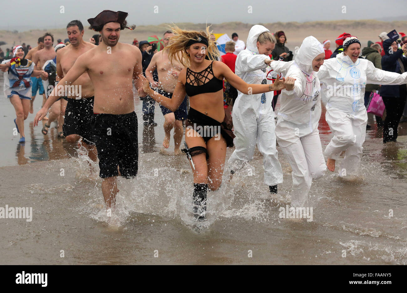 Porthcawl, UK. Friday 25 December 2015 Christmas swimmers in fancy dress costumes run towards  the seaRe: Hundreds of people in fancy dress, have taken part in this year's Christmas Swim in Porthcawl, south Wales. Credit:  D Legakis/Alamy Live News Stock Photo