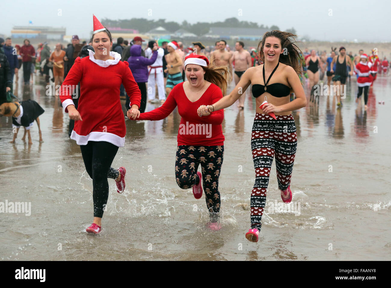 Porthcawl, UK. Friday 25 December 2015 Christmas swimmers in fancy dress costumes run towards  the seaRe: Hundreds of people in fancy dress, have taken part in this year's Christmas Swim in Porthcawl, south Wales. Credit:  D Legakis/Alamy Live News Stock Photo