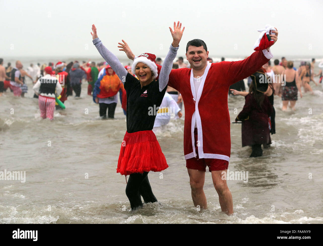 Porthcawl, UK. Friday 25 December 2015 A couple of Christmas swimmers in Santa outfits in the seaRe: Hundreds of people in fancy dress, have taken part in this year's Christmas Swim in Porthcawl, south Wales. Credit:  D Legakis/Alamy Live News Stock Photo