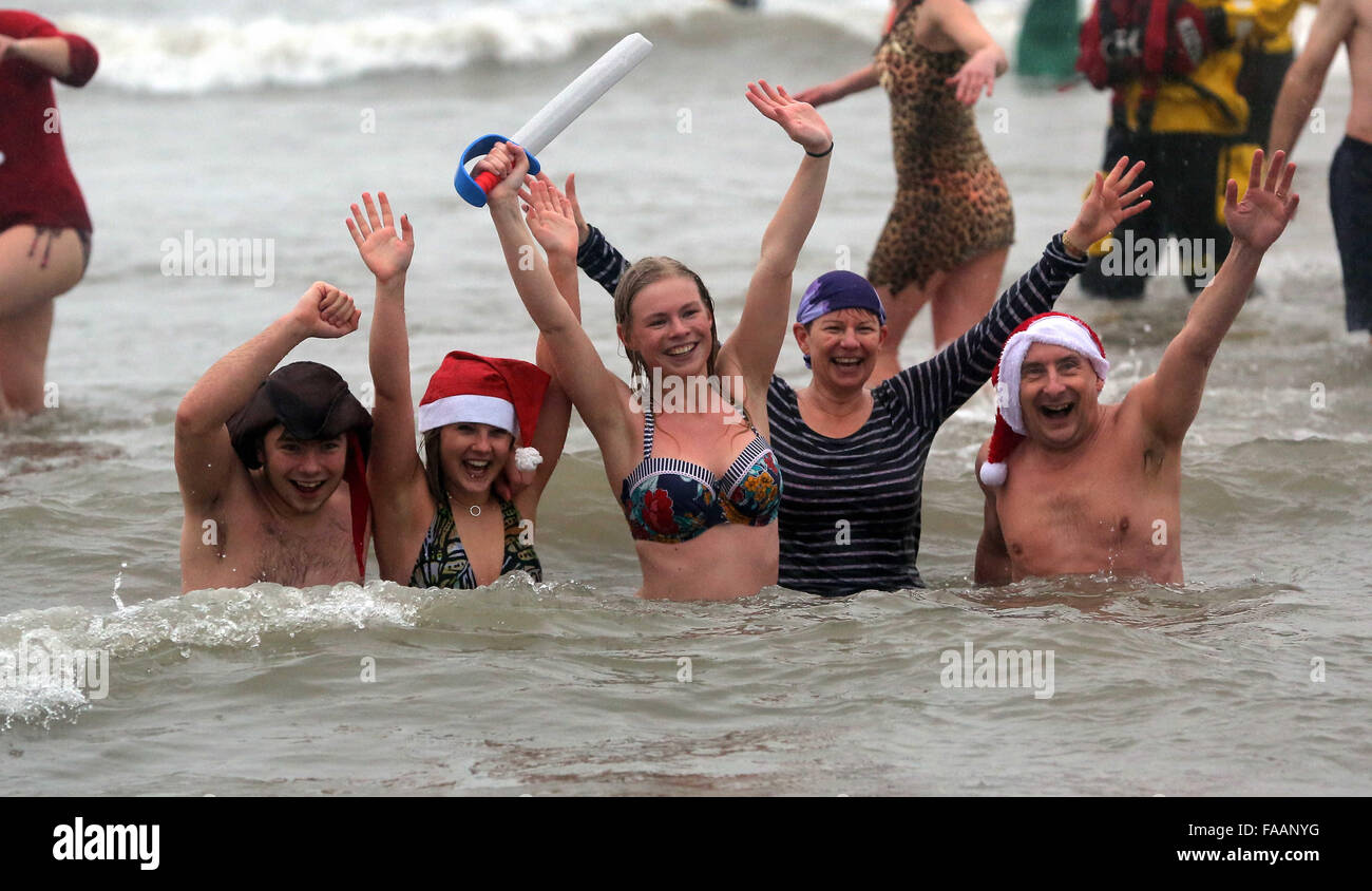 Porthcawl, UK. Friday 25 December 2015 A group of people wave from the seaRe: Hundreds of people in fancy dress, have taken part in this year's Christmas Swim in Porthcawl, south Wales. Credit:  D Legakis/Alamy Live News Stock Photo