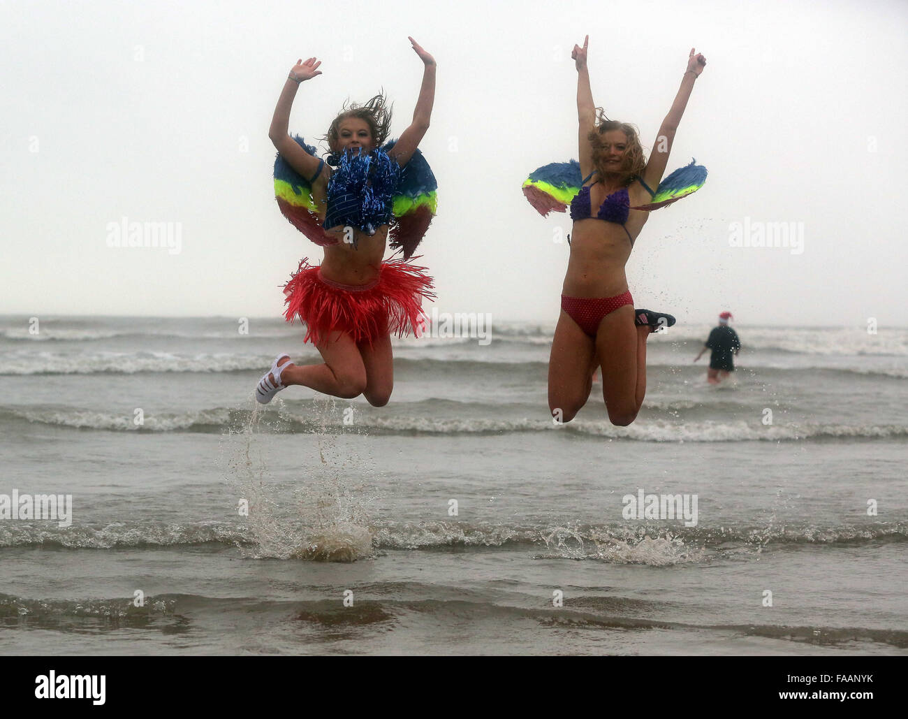 Porthcawl, UK. Friday 25 December 2015 Two young ladies in angel wingsRe: Hundreds of people in fancy dress, have taken part in this year's Christmas Swim in Porthcawl, south Wales. Credit:  D Legakis/Alamy Live News Stock Photo