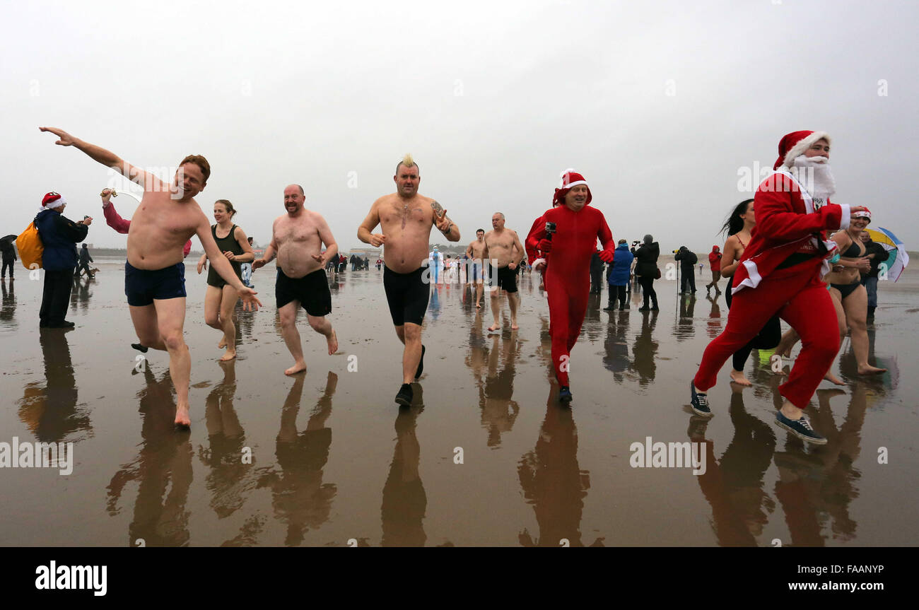 Porthcawl, UK. Friday 25 December 2015 Christmas swimmers run towards the seaRe: Hundreds of people in fancy dress, have taken part in this year's Christmas Swim in Porthcawl, south Wales. Credit:  D Legakis/Alamy Live News Stock Photo