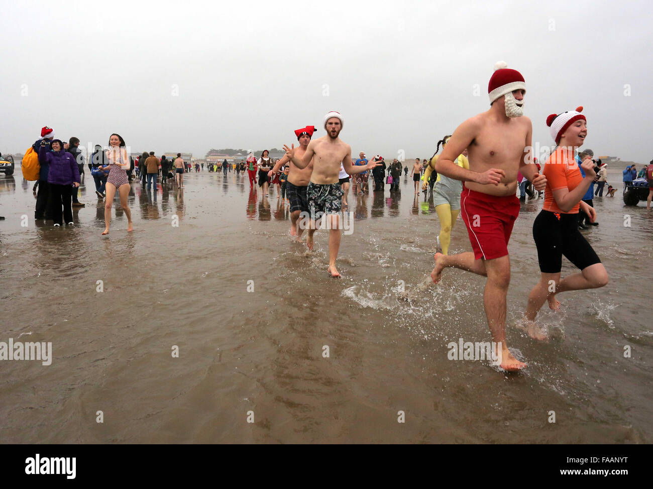 Porthcawl, UK. Friday 25 December 2015 Christmas swimmers run towards the seaRe: Hundreds of people in fancy dress, have taken part in this year's Christmas Swim in Porthcawl, south Wales. Credit:  D Legakis/Alamy Live News Stock Photo