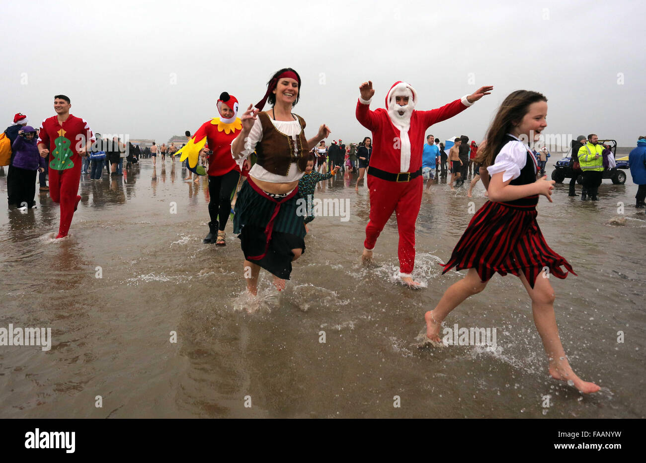 Porthcawl, UK. Friday 25 December 2015 Christmas swimmers run towards the seaRe: Hundreds of people in fancy dress, have taken part in this year's Christmas Swim in Porthcawl, south Wales. Credit:  D Legakis/Alamy Live News Stock Photo