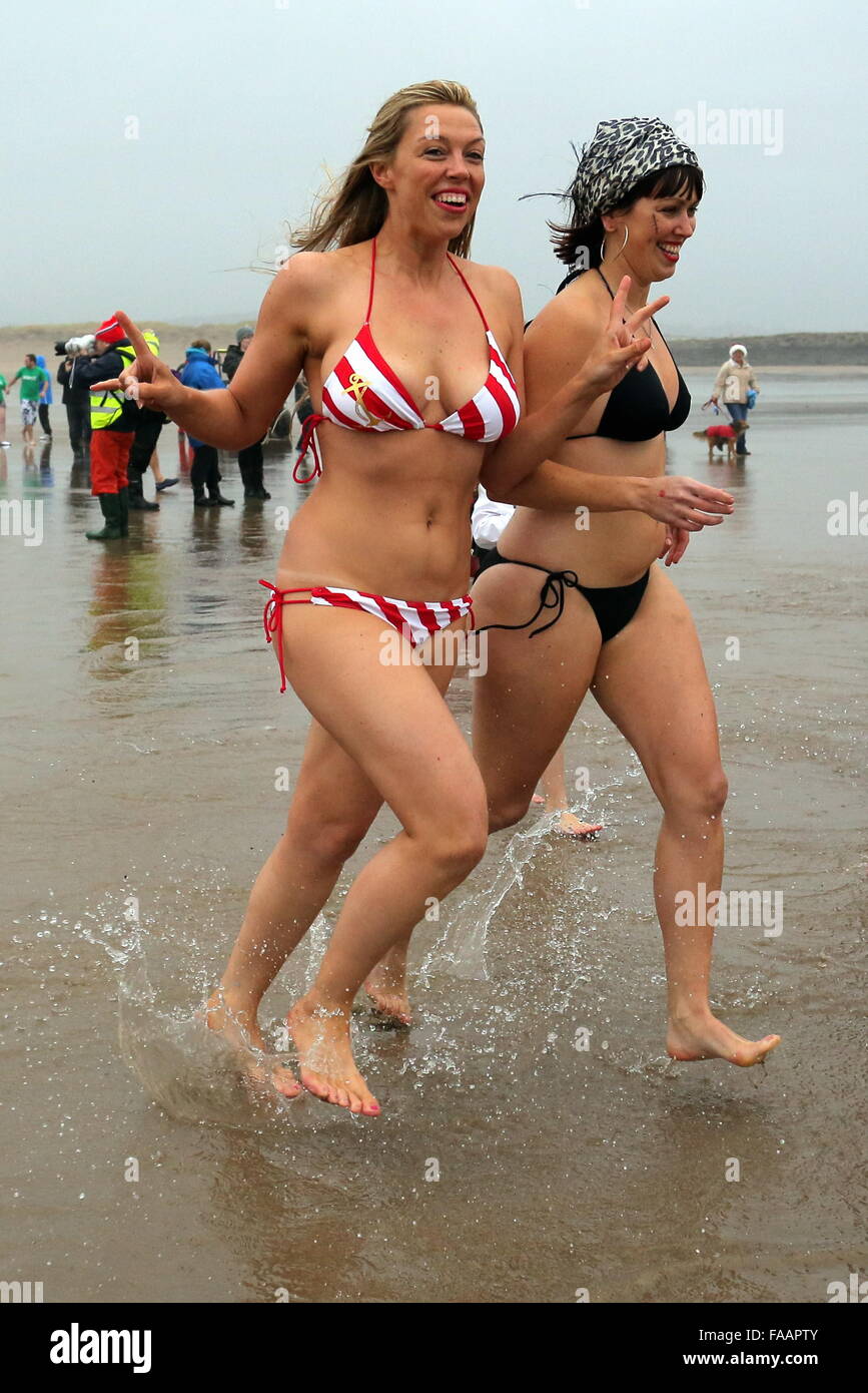 Porthcawl, UK. Friday 25 December 2015 Two female Christmas swimmers in bikinis run towards the seaRe: Hundreds of people in fancy dress, have taken part in this year's Christmas Swim in Porthcawl, south Wales. Credit:  D Legakis/Alamy Live News Stock Photo