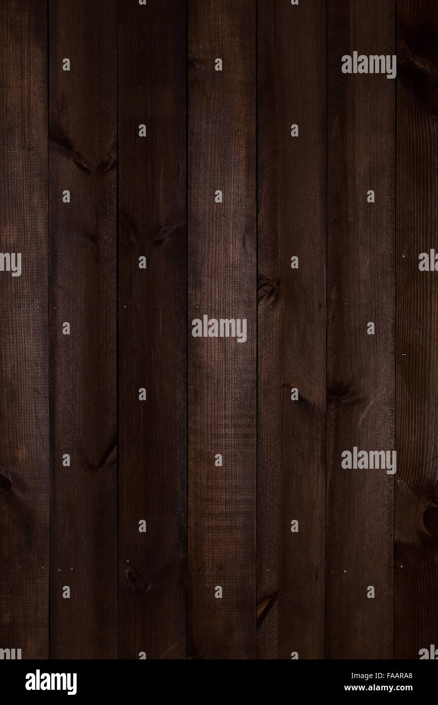 Wooden wall made of poorly processed dark old planks arranged Vertical Stock Photo
