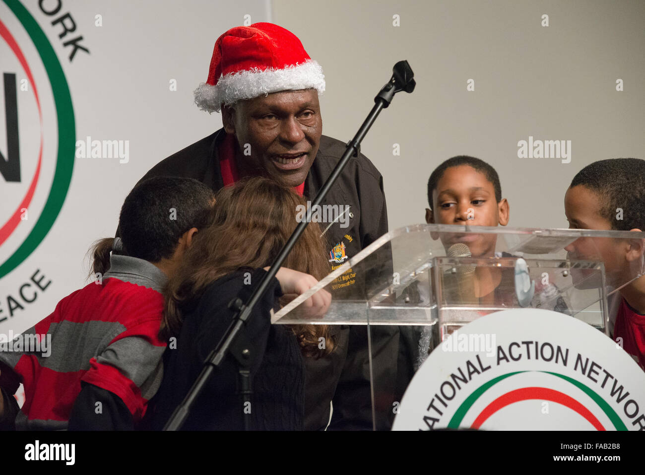 New York, United States. 25th Dec, 2015. New York State Assemblyman Keith Wright leads a group of children in wishing the attendees of the holiday meal 'Happy Holidays.' New York City Mayor Bill de Blasio and his daughter Chiara joined Reverend Al Sharpton at the House of Justice, the National Action Network's (NAN) headquarters and community center on West 145th Street in Harlem, to participate in the NAN's annual holiday meal and toy give-away for the less fortunate. © Albin Lohr-Jones/Pacific Press/Alamy Live News Stock Photo