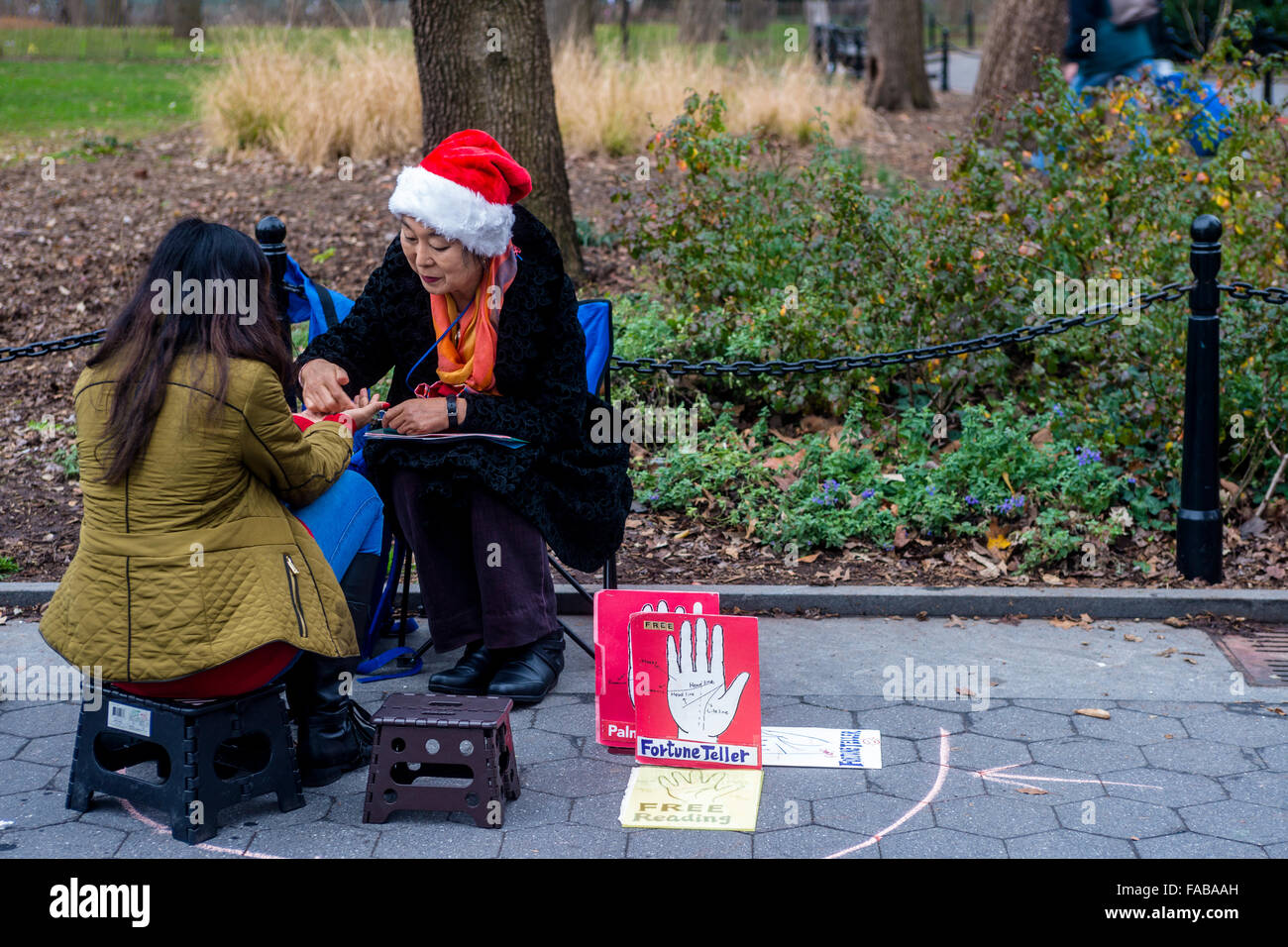 New York, NY 25 December 2015 - A Palm reader predicts a woman's on Christmas Day in Washington Square Park. Temperatures reached into the mid 60s on this unseasonably warm Christmas. ©Stacy Walsh Rosenstock/Alamy Stock Photo