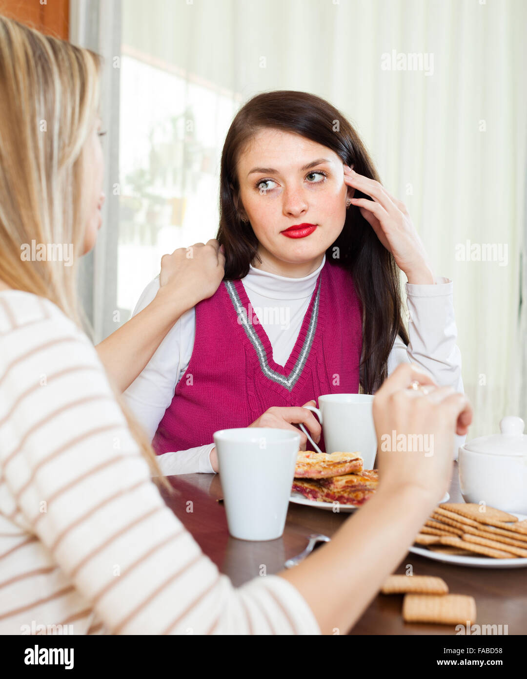Young woman comforting depressed friend in home Stock Photo - Alamy