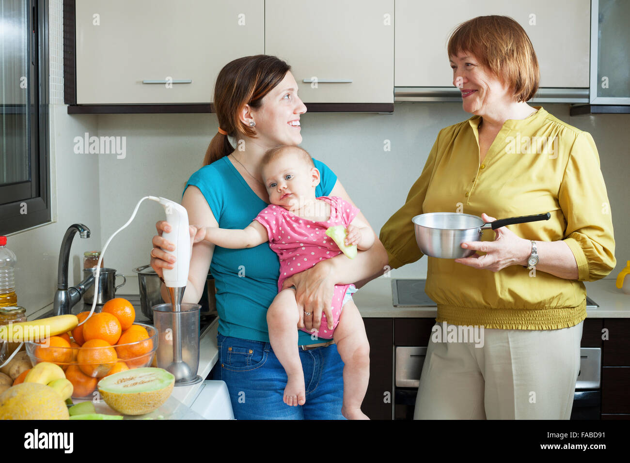 Happy women of three generations with blender in domestic kitchen at home Stock Photo