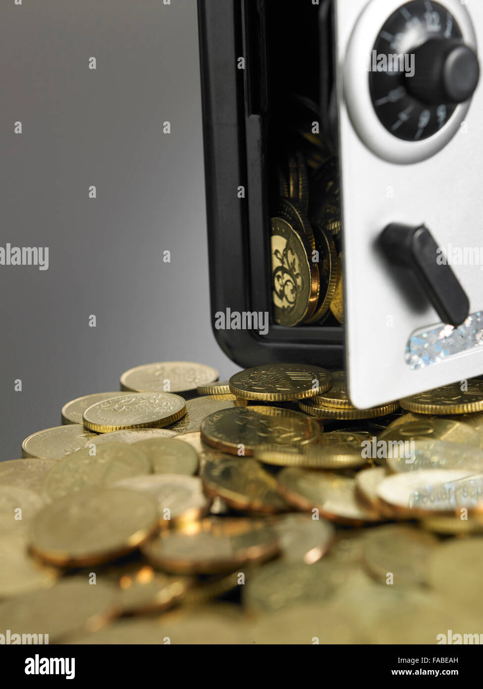 coins in front of the mini safe box Stock Photo