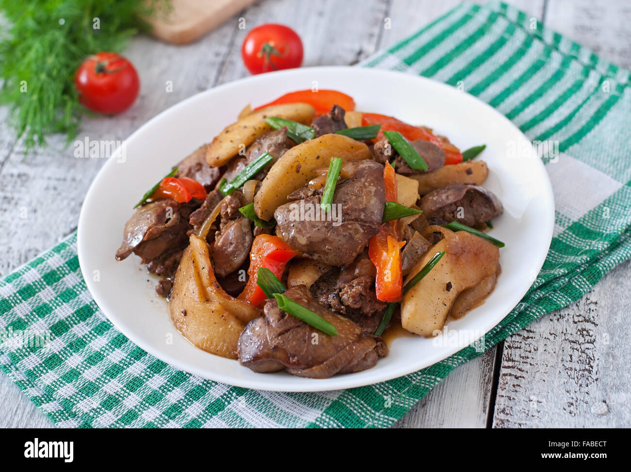 Roast chicken liver with vegetables on wooden background Stock Photo