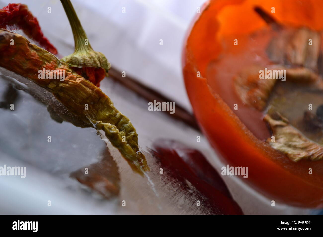 Frozen  peppers persimmon  in melting ice Stock Photo