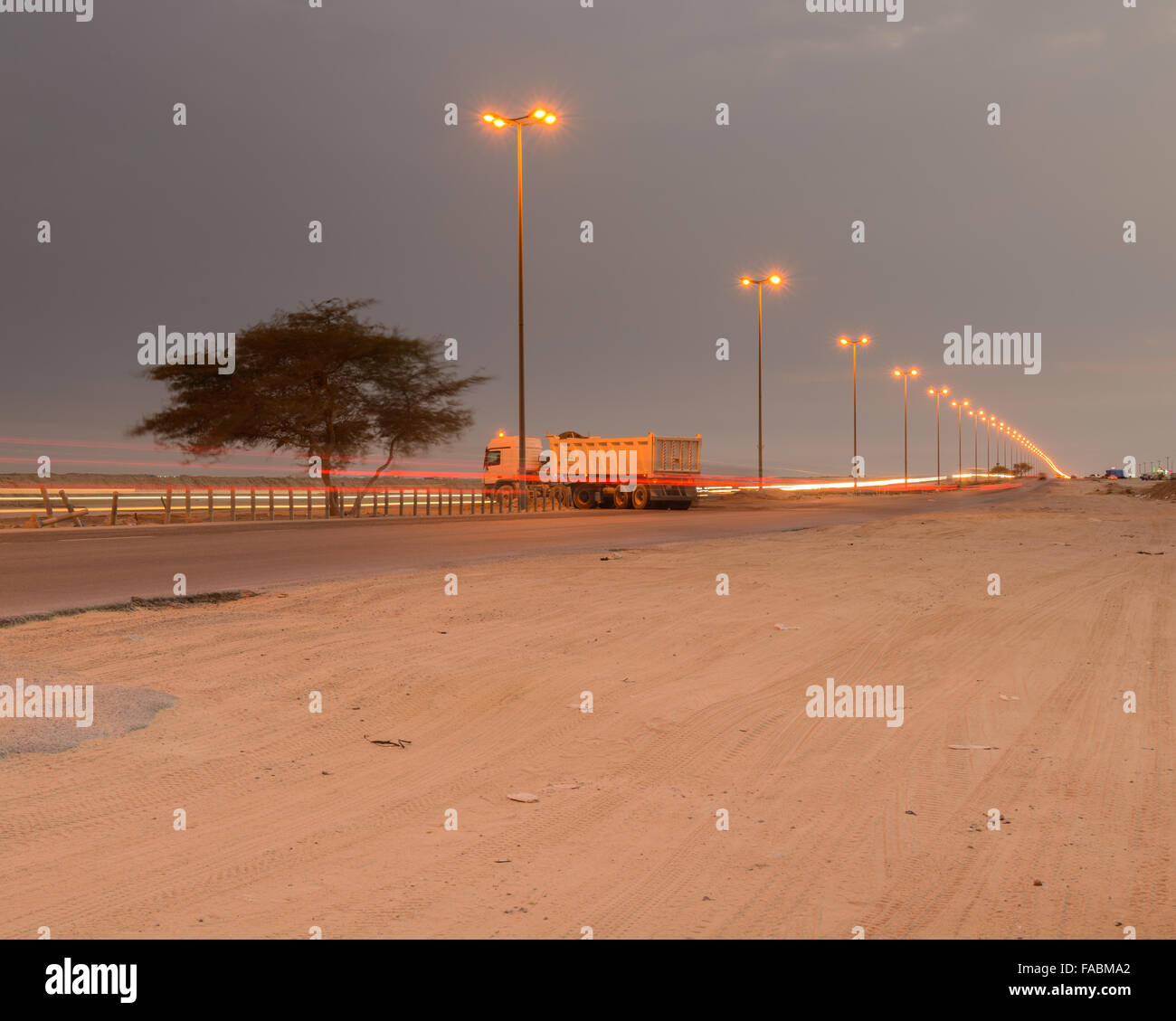 Truck waiting to do a u-turn on the Wafra road at night, Kuwait Stock Photo