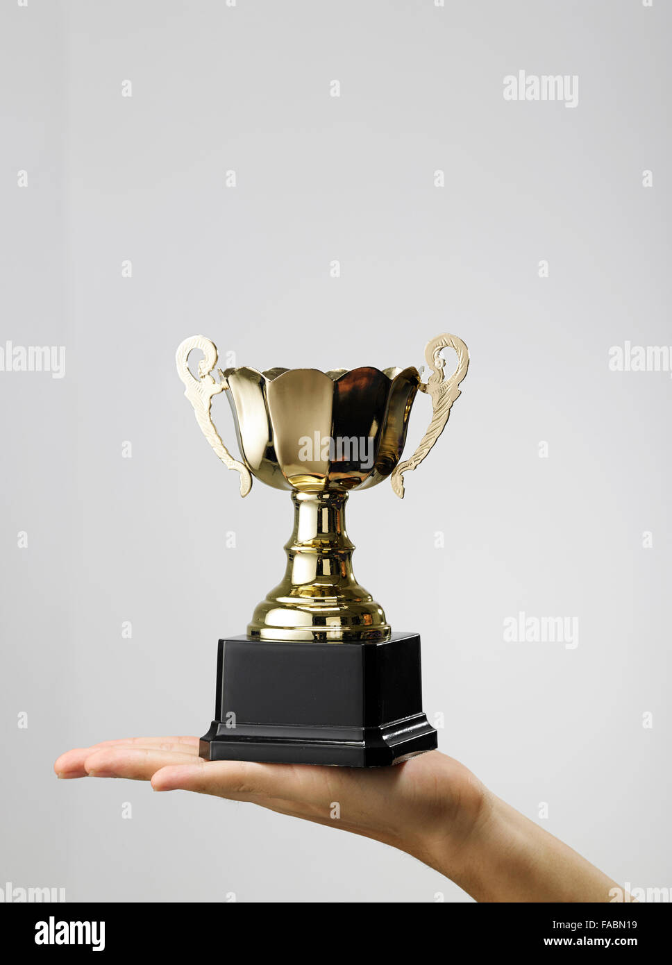 Man holding a champion golden trophy Stock Photo