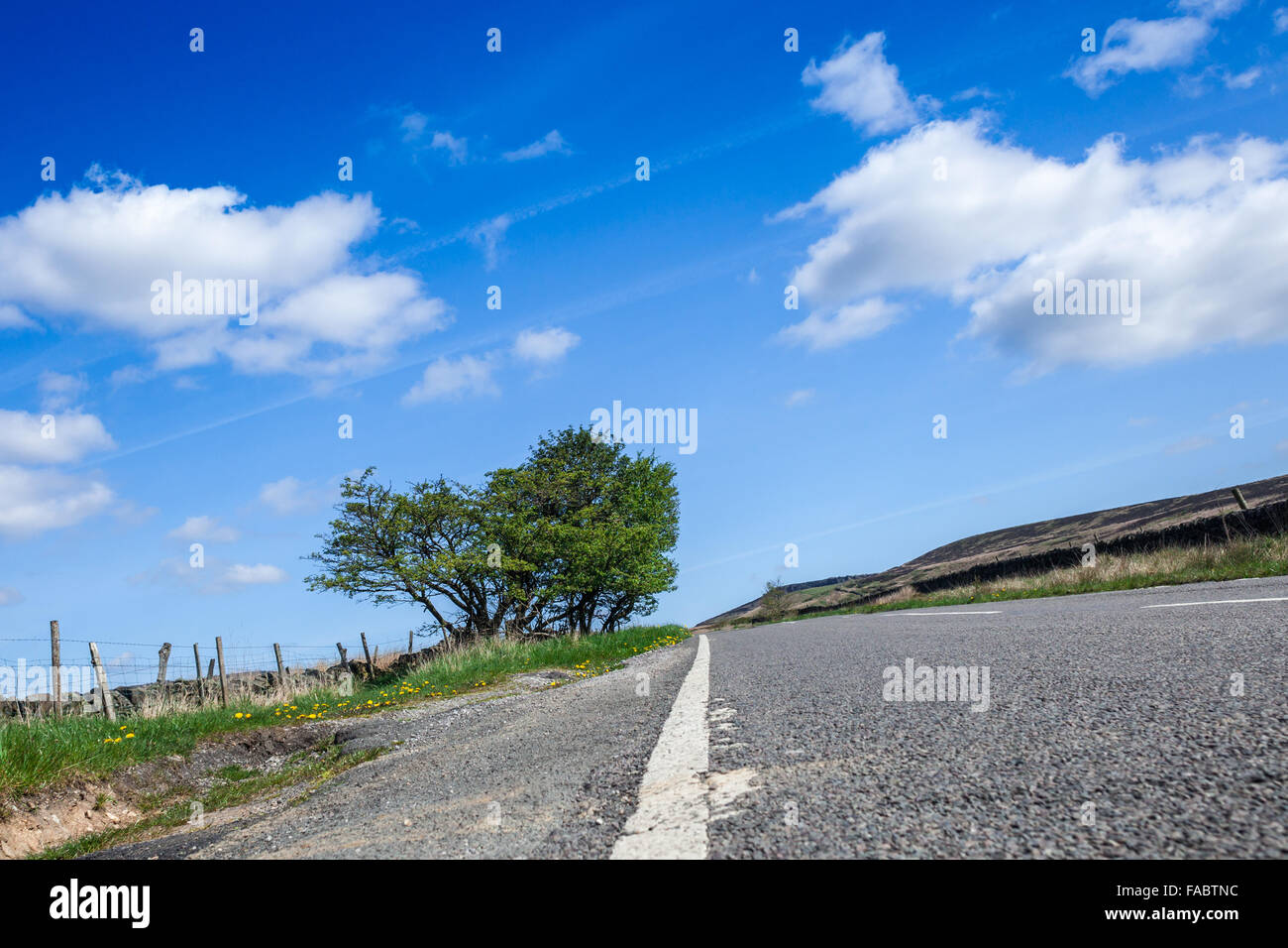 Empty Asphalt Countryside Road  and Cumulus Clouds on Blue Sky Stock Photo