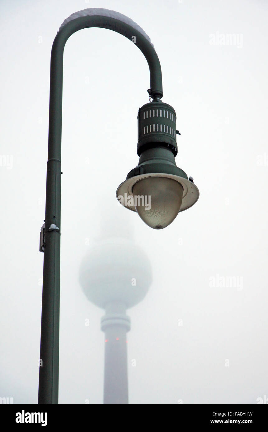 Street retro lampost covered with a snow in Berlin, Germany. Berlin Television Tower on a background Stock Photo