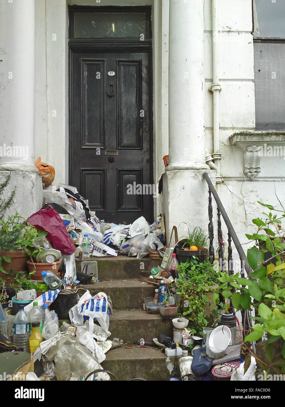 Rubbish by eccentric hoarder pilled up outside expensive neglected property 17 Portland Road, Holland Park, London, England Stock Photo