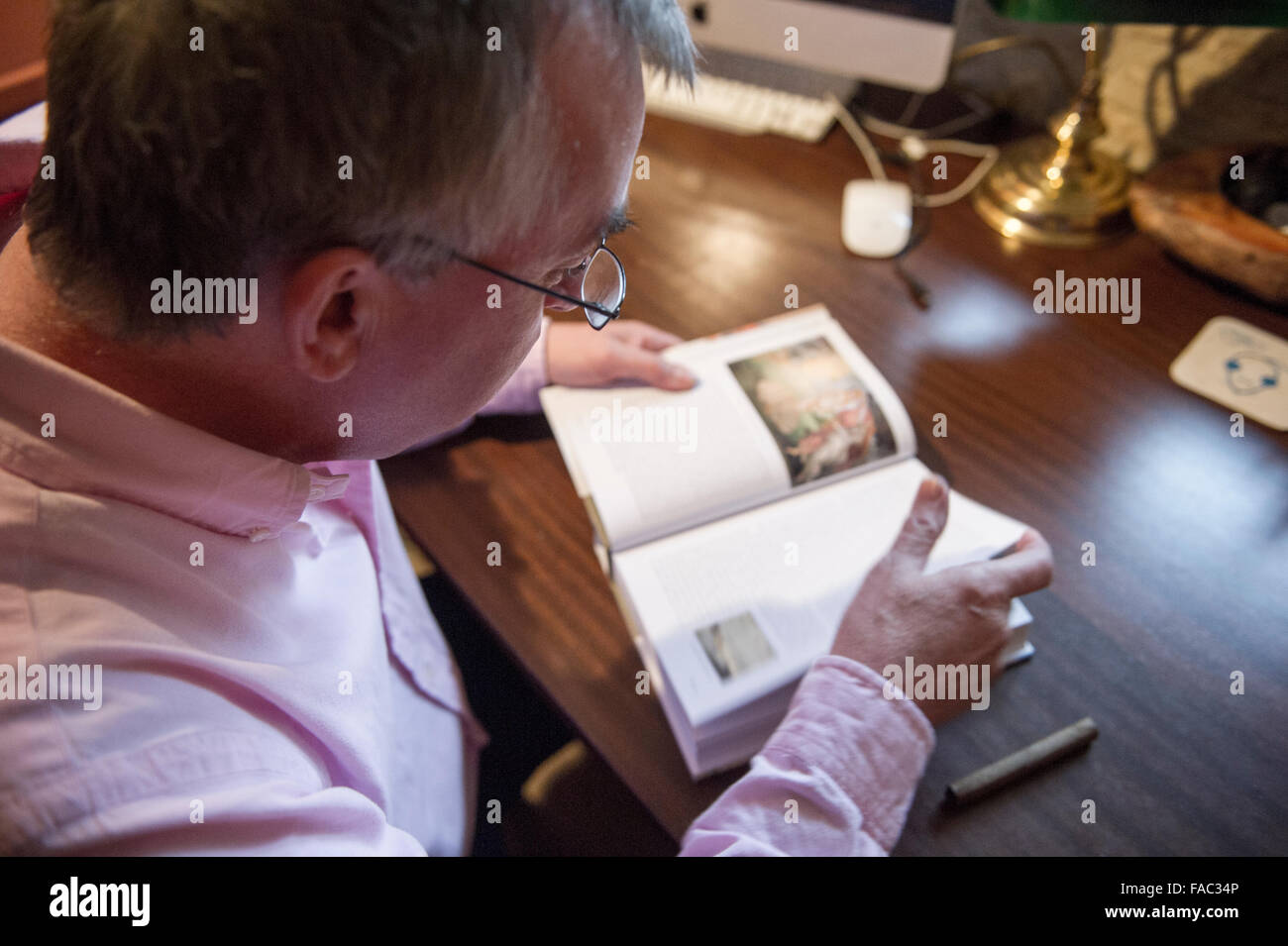 A man studies a favourite book in his study Stock Photo - Alamy