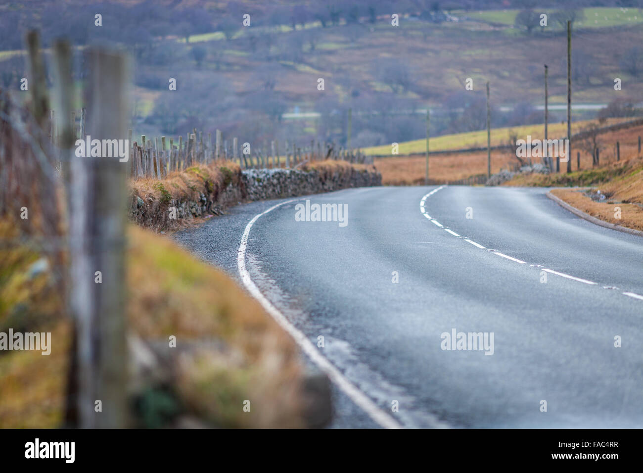Welsh Asphalt Road with Stony Fence, Blurred Background Stock Photo