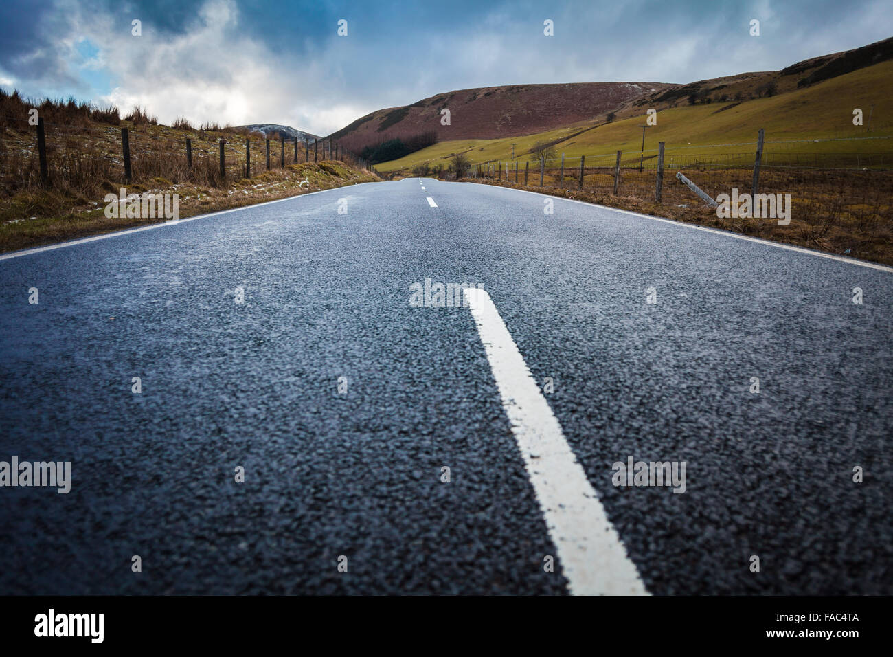 Wide Asphalt Road among Welsh Scenery, Snowdonian National Park. Shallow Depth of Field Stock Photo