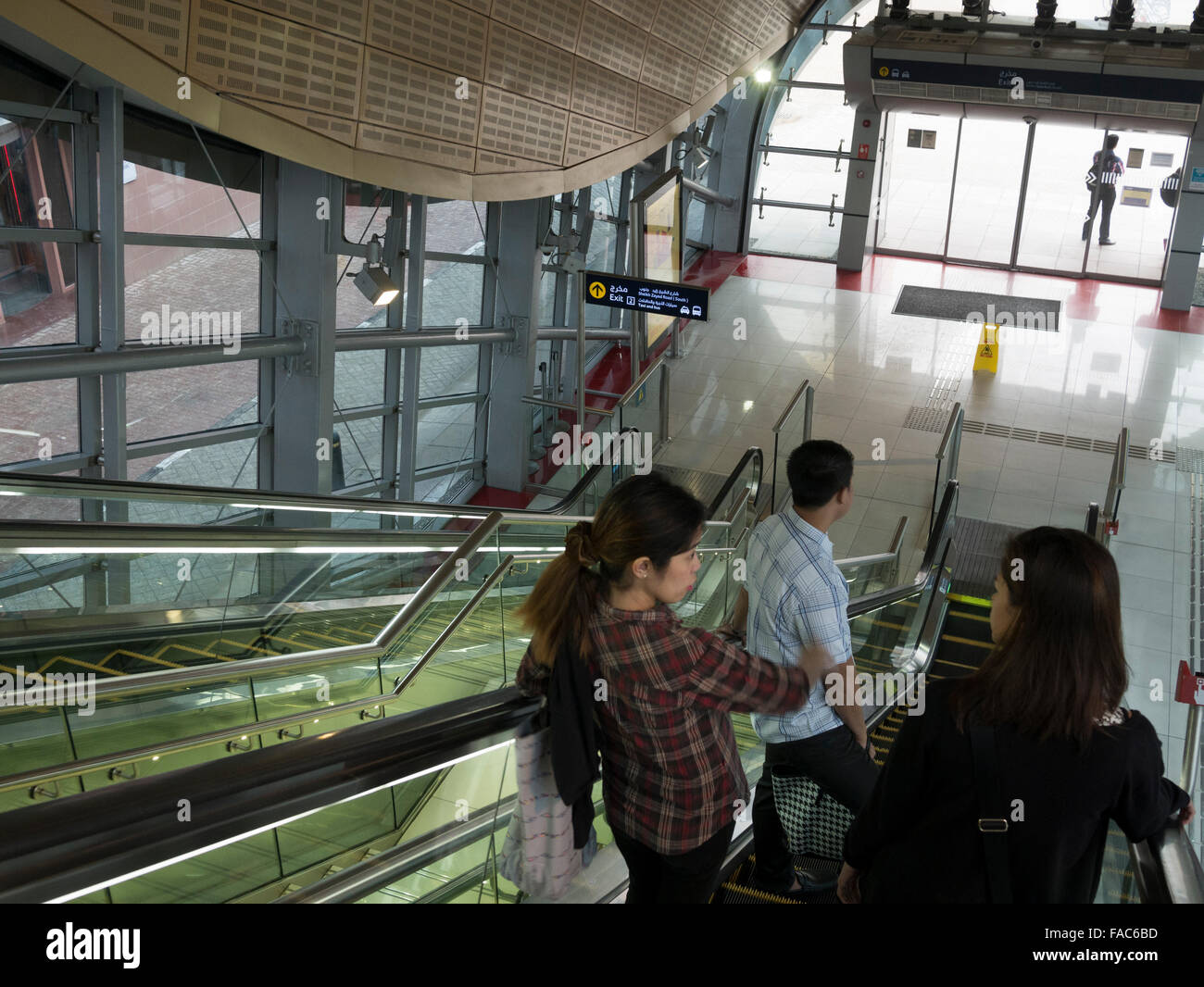 Group of commuters going down escalator in Dubai metro station Stock Photo