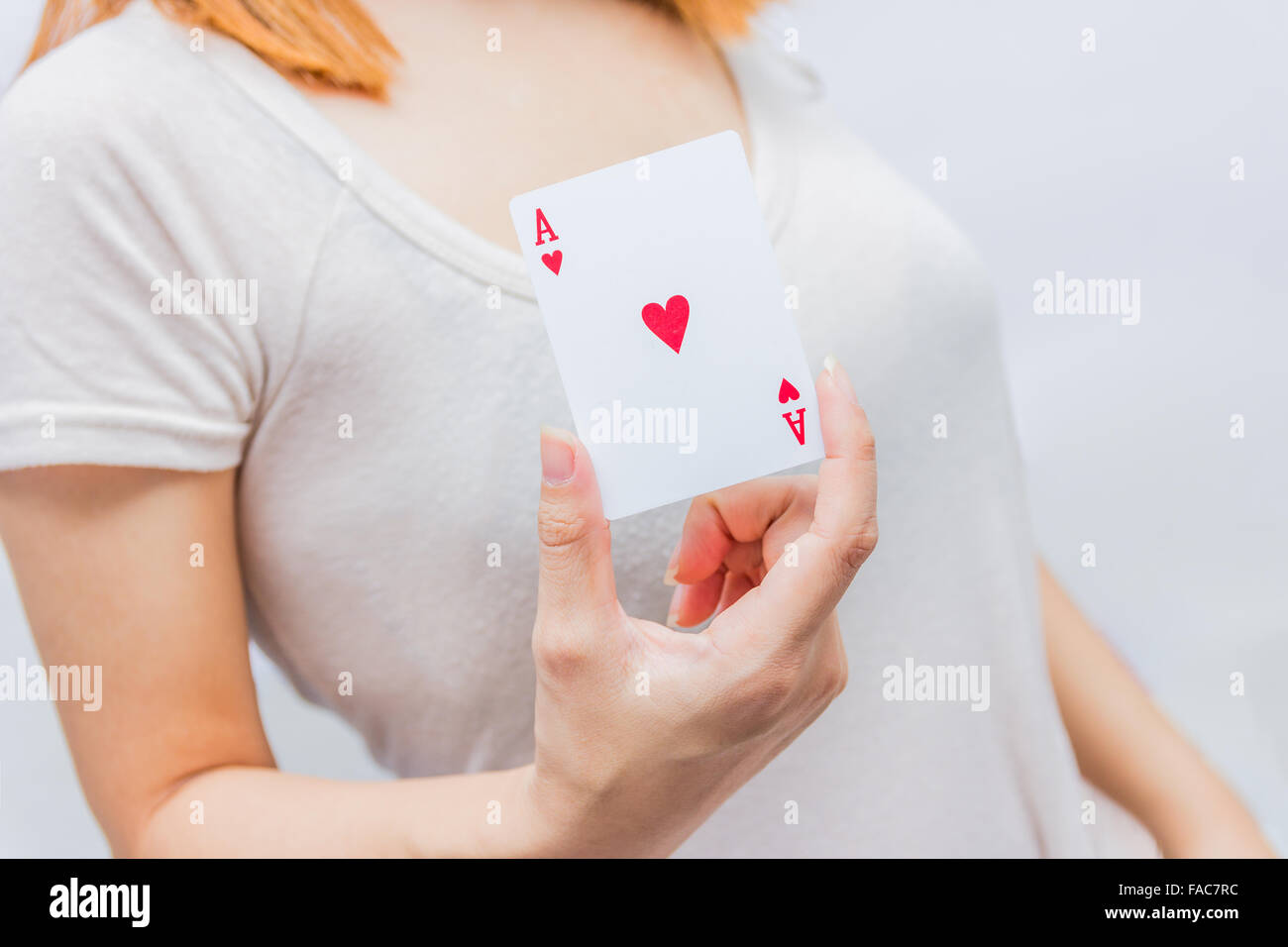 young woman holding in hand poker card with combination of Full House. in focus hand and poker card. Stock Photo