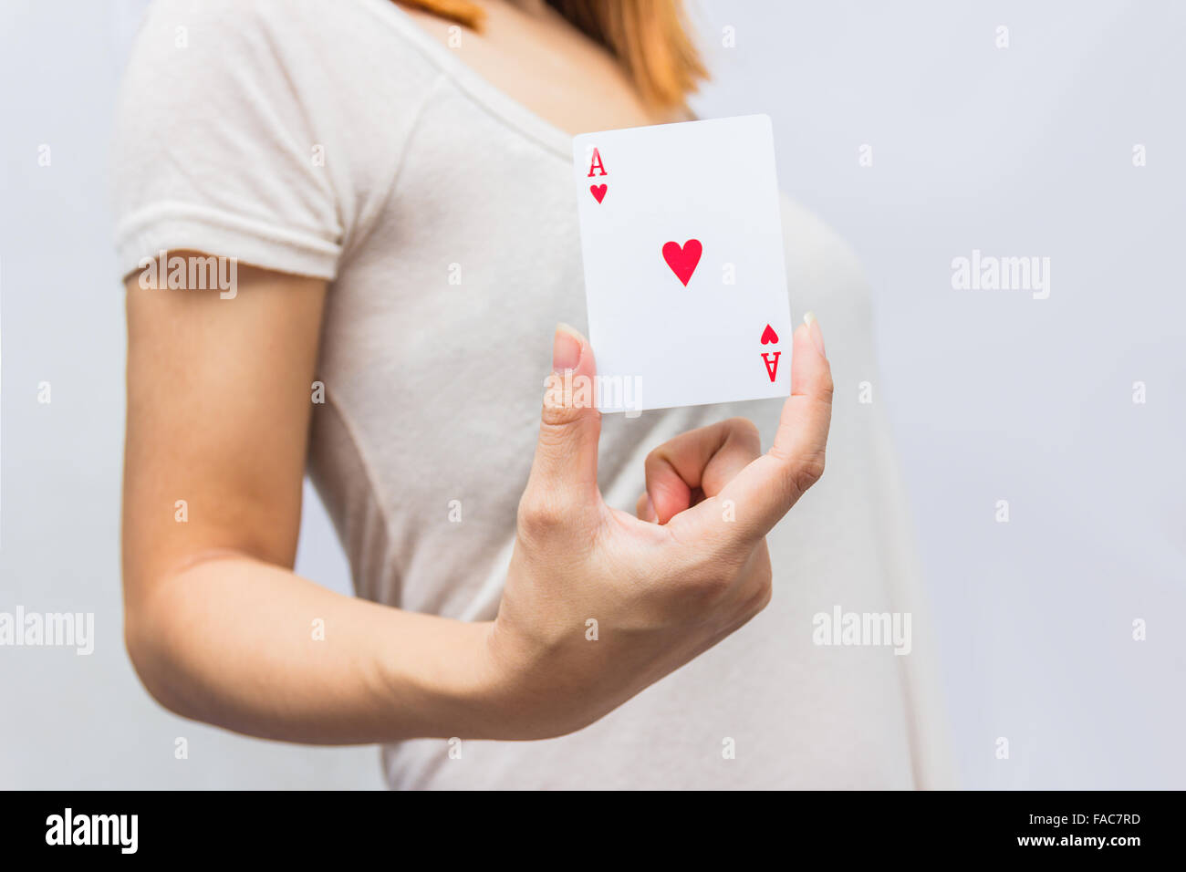 young woman holding in hand poker card with combination of Full House. in focus hand and poker card. Stock Photo